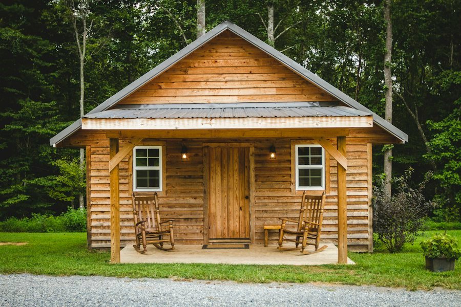 Small wooden cabin with a front porch and two rocking chairs