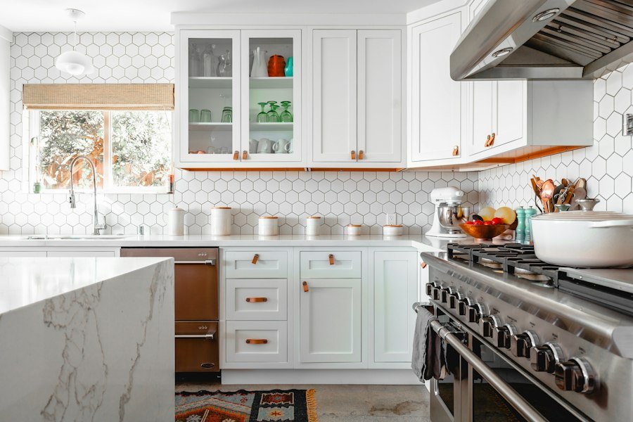 Bright finished kitchen with white cabinets and marble island